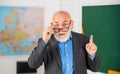 Answer and question. senior man teacher at blackboard. bearded tutor in glasses near geography map. back to school Royalty Free Stock Photo