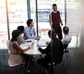 Answering his question. a businessman giving a whiteboard presentation to a group of colleagues in a boardroom. Royalty Free Stock Photo