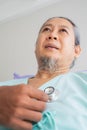 Ant eye view of elderly patient man unhappy, suffer, sadness from sick looking forward and doctor using stethoscope on heart. Royalty Free Stock Photo