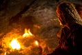 Female tourist at night rest next to natural small fires on Mount Chimaera Yanartas, Turkey