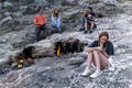 Tourists rest next to natural small fires on Mount Chimaera Yanartas, Turkey