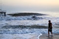 Antalya, Turkey - December 15, 2019: View from beach to water of sea, waves with white foam and black silhouette of person in a