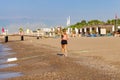 Female runner jogging during outdoor workout on beach in the morning. Running young blonde woman.