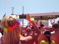 Young woman at outdoor music festival taking pictures using mobile phone Royalty Free Stock Photo