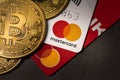 Antalya, Turkey - November 1, 2021: Bitcoin cryptocurrency standing on a MasterCard credit card