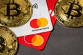 Antalya, Turkey - November 1, 2021: Bitcoin cryptocurrency standing on a MasterCard credit card