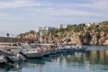 Antalya, Turkey - November 15, 2022: Small fishing boats docked in a harbor with cliff Royalty Free Stock Photo