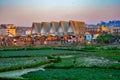 Tall buildings and dirty slum houses, rise fields in front. Green area near Antananarivo with rice plantation and poor homes