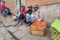 Antananarivo, Madagascar - April 24, 2019: Three unknown Malagasy men sitting on sidewalk, selling tomatoes. Food is usually sold