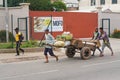 Antananarivo, Madagascar - April 24, 2019: Unknown Malagasy man pulling wooden cart with fruit on main street. There are not many
