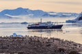 Antarctic cruise ship in the lagoon among icebergs and Gentoo pe