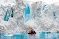 Glacier Ice Shelf Wall In Antarctica, People In Zodiac In Front Of Edge Of Glacier