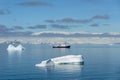 Antarctic landscape in with expedition vessel and iceberg