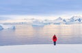 Antarctic tourist in red parka in front of Antarctic iceberg landscape at Portal Point