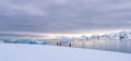 Antarctic tourists in red parkas climb an Antarctic iceberg landscape at Portal Point Antarktika