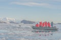 Antarctic tourists observe a leopard seal (Hydrurga leptonyx) on an ice floe in Cierva Cove from the Zodiac.