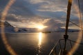 Antarctica calm midnight sunset lens flare from sailboat