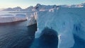 Antarctica huge iceberg with caves in sunset