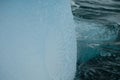 Antarctica unique shiny blue iceberg art texture in rippled water