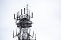 Top of Antenna used for mobile phones against grey sky, almost isolated. Royalty Free Stock Photo