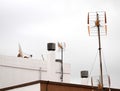 Antennas on a Roof over a Cloudy Sky Royalty Free Stock Photo