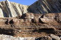 Anthropocene. Industrial deposits stratum in the foreground against eocene rock layers in the background Royalty Free Stock Photo