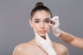 Beautician hands in gloves examining woman face