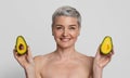 Anti-Aging Foods. Beautiful Nude Mature Woman Holding Two Avocado Halves Royalty Free Stock Photo