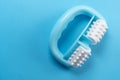 Anti-cellulite manual turquoise plastic massager with silicone rollers with pimples on a blue bright background Royalty Free Stock Photo