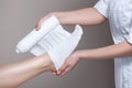 Anti-cellulite procedure-STYX wrap.The cosmetologist wraps the leg of the customer.