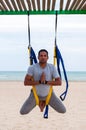 Anti-gravity Yoga, man doing yoga exercises on the sea background Royalty Free Stock Photo