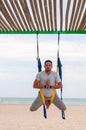 Anti-gravity Yoga, man doing yoga exercises on the sea background Royalty Free Stock Photo