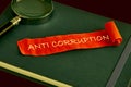 Anti money laundering business and government concept. ANTI CORRUPTION words on a red piece of paper lying on a green business