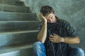 Campaign vs homophobia with young sad and depressed college student man sitting on staircase desperate victim of harassment