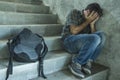 Campaign vs homophobia with young sad and depressed college student man sitting on staircase desperate victim of harassment