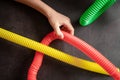 anti stress sensory pop tube toys in a children`s hands. a little happy kids plays with a poptube toy on a black table. toddlers
