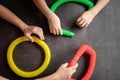 anti stress sensory pop tube toys in a children`s hands. a little happy kids plays with a poptube toy on a black table. toddlers