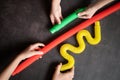 anti stress sensory pop tube toys in a children`s hands. a little happy kids plays with a poptube toy on a black table. toddlers