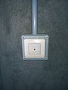 Anti-theft pushbutton with light grey surface on cement wall in