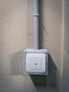 Anti-theft pushbutton with light grey surface on cement wall in