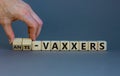 Anti-vaxxers symbol. Doctor turns cubes, changes words `vaxxers` to `anti-vaxxers`. Beautiful grey background. Copy space. Med Royalty Free Stock Photo