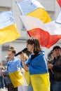 Anti-war protest in Poland woman speaking while wrapped in a Ukrainian flag