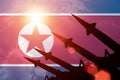 Antiaircraft rockets silhouettes on background of North Korea flag.