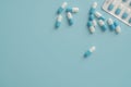 Antibiotic capsule pills on blue background. Prescription drugs. Blue-white capsule pills. Antibiotic drug resistance concept.