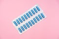 Antibiotics and antimicribial pills for treatment sexually transmitted diseases STD, blue capsules in blister on pink background