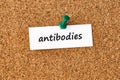 Antibodies. Word written on a piece of paper, cork board background