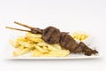 Anticuchos, Peruvian cuisine, grilled skewered beef heart meat with fries potatoes (french fries). Royalty Free Stock Photo