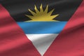 Antigua and Barbuda flag with big folds waving close up under the studio light indoors. The official symbols and colors