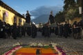 People wearing black robes in a street of the old city of Antigua during a procession of the Holy Week in Antigua, Guatemala