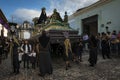 Women dressed in black carrying a giant float in a street of the old city of Antigua during a procession of the Holy Week, in Anti